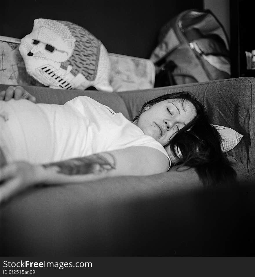 Woman in White Shirt Sleeping on Gray Fabric Sofa