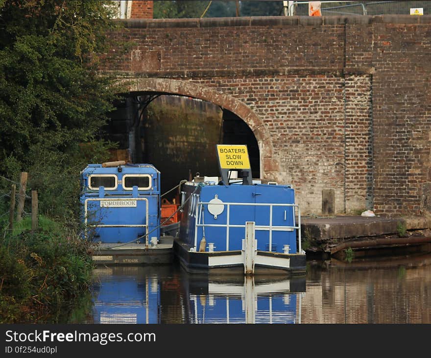 Boats entering tunnel in water canal on sunny day. Boats entering tunnel in water canal on sunny day.