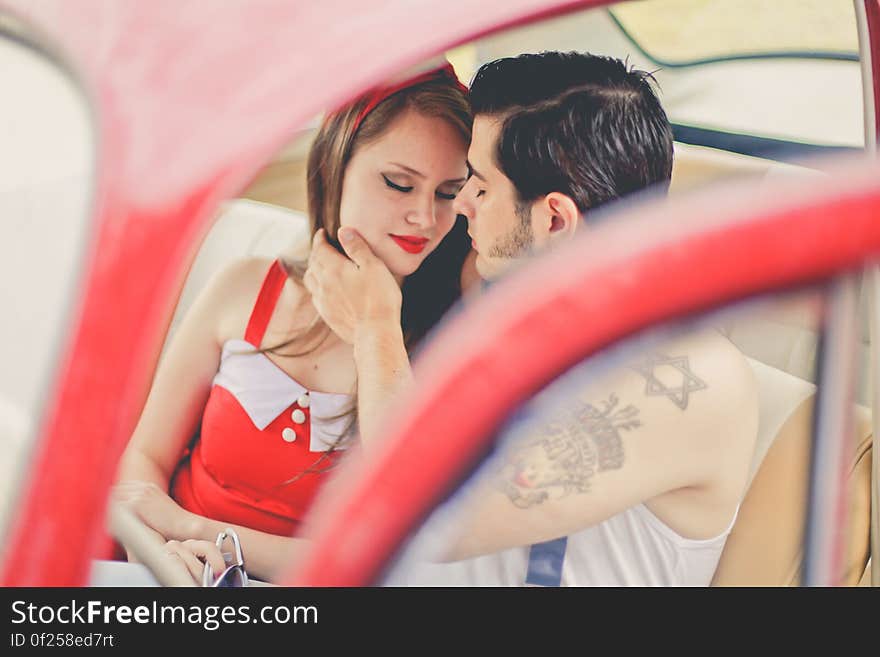 A couple sitting in an antique car. A couple sitting in an antique car.