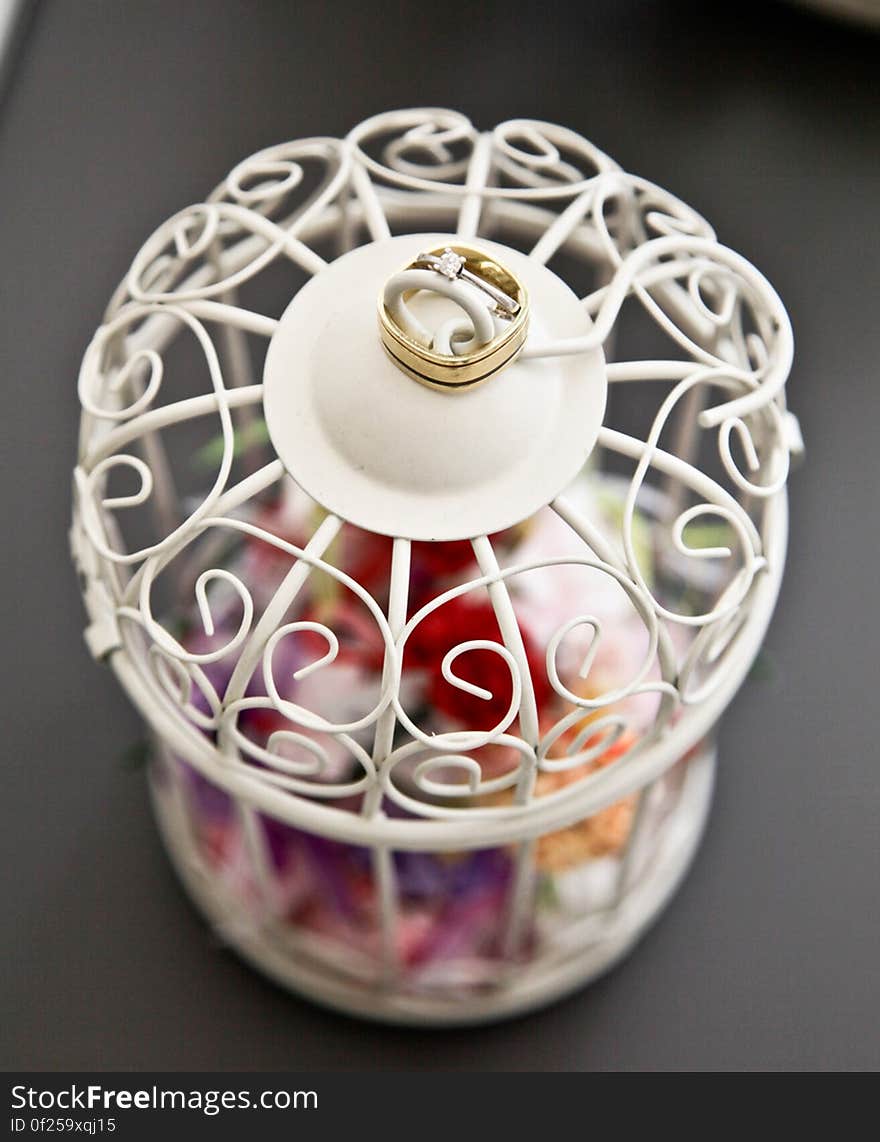 A wedding ring on a white lantern with colorful petals. A wedding ring on a white lantern with colorful petals.