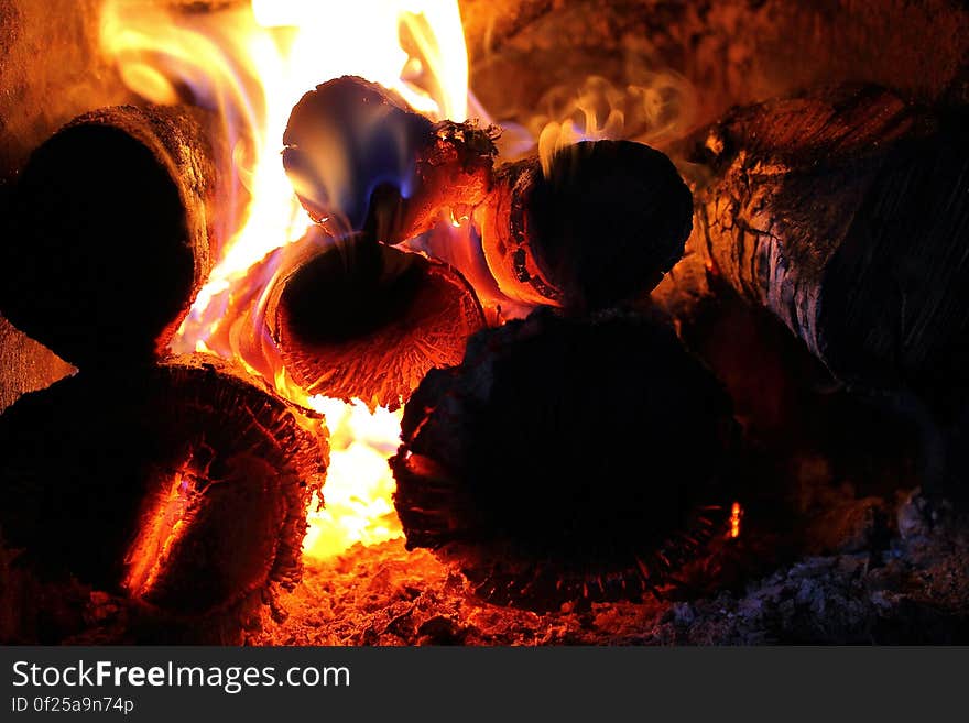 A close up of a fireplace with burning wood.