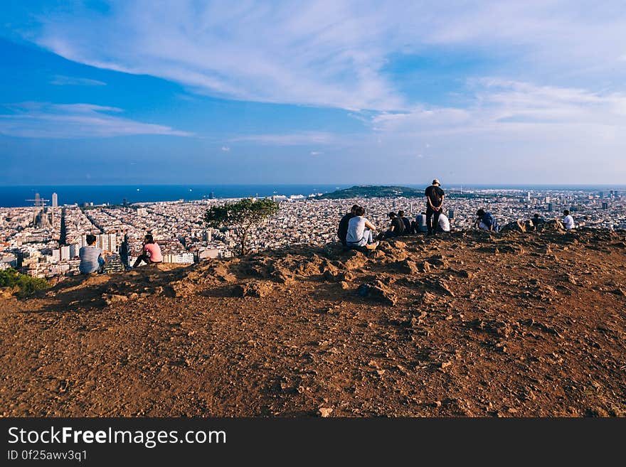 A group of people sitting on the hills looking at the city of Barcelona. A group of people sitting on the hills looking at the city of Barcelona.