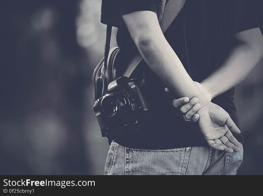 A photographer with a camera holding hands behind back. A photographer with a camera holding hands behind back.