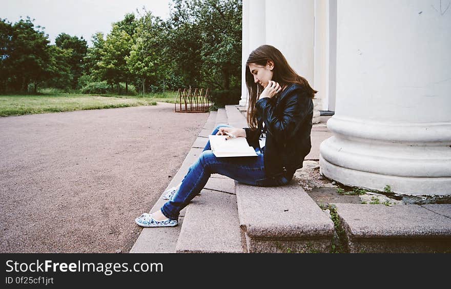 Woman in Black Leather Jacket Siting on Concrete Stairs