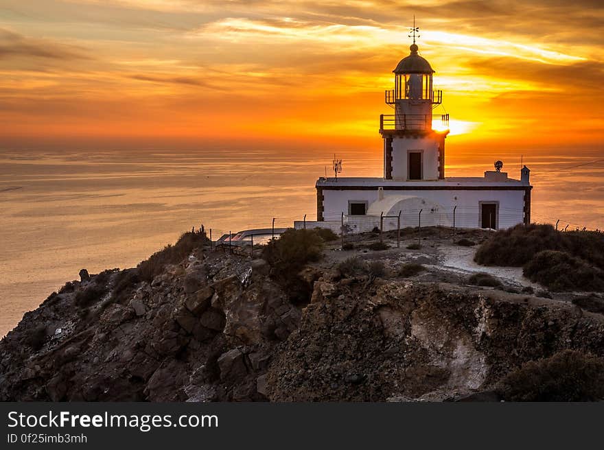 The Akrotiri Lighthouse in Santorini, Greece, at sunset.