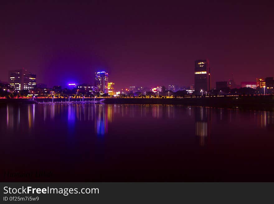 A city skyline at night reflecting from the water. A city skyline at night reflecting from the water.