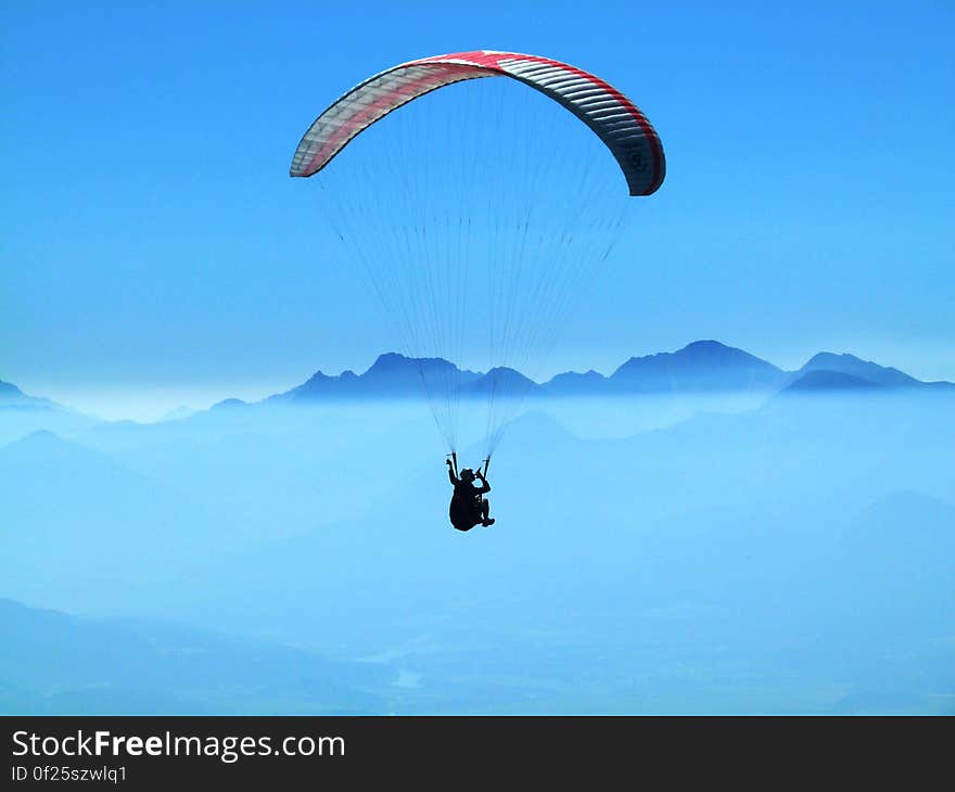 Person Doing Paragliding Above Clouds during Daytime