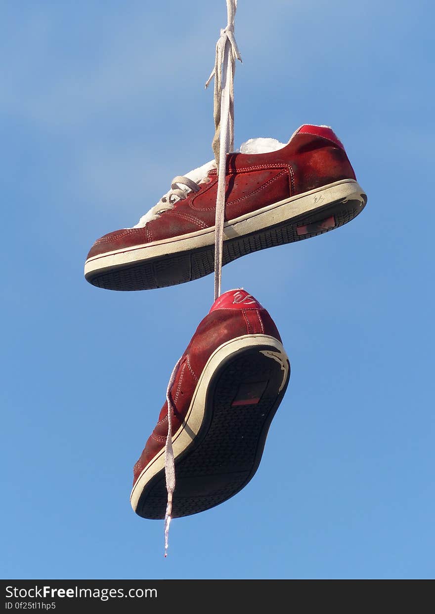 Red and White Hanging Sneakers during Daytime