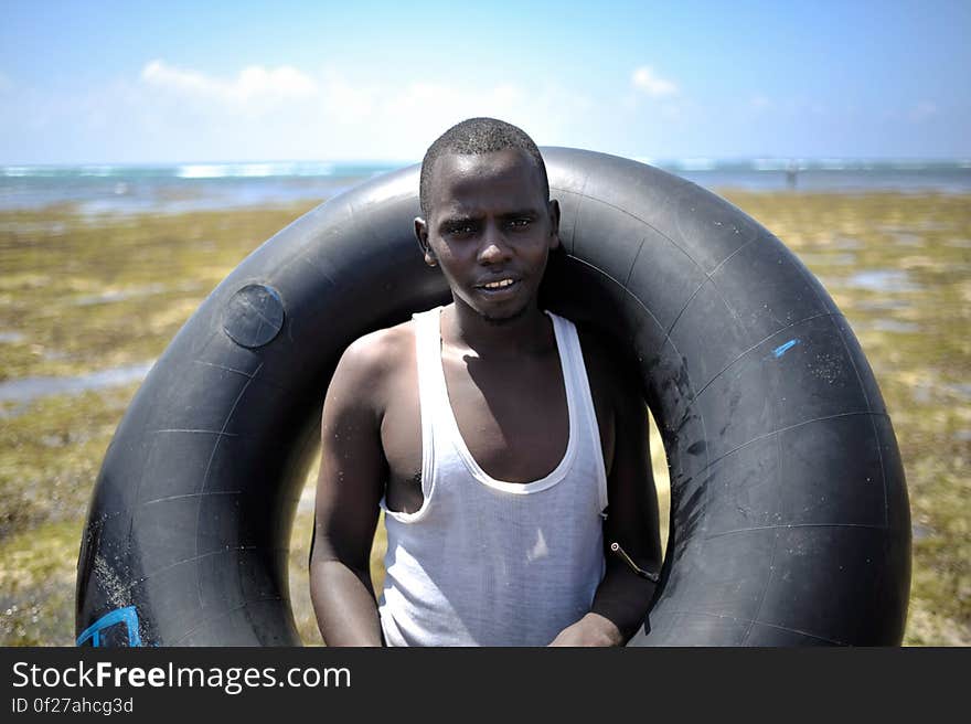 A young man poses with an old inner tube on a sand bank off of Lido beach in the Somali capital of Mogadishu on January 31. The Mogadishu lifeguards, consisting entirely of a volunteer force of fisherman, began patrolling Lido beach in September 2013 after a spate of drownings. Mogadishu&#x27;s beaches have become a popular destination for the city&#x27;s residents since al Shabab withdrew the majority of its militants from the city in 2011. AU UN IST PHOTO / Tobin Jones. A young man poses with an old inner tube on a sand bank off of Lido beach in the Somali capital of Mogadishu on January 31. The Mogadishu lifeguards, consisting entirely of a volunteer force of fisherman, began patrolling Lido beach in September 2013 after a spate of drownings. Mogadishu&#x27;s beaches have become a popular destination for the city&#x27;s residents since al Shabab withdrew the majority of its militants from the city in 2011. AU UN IST PHOTO / Tobin Jones