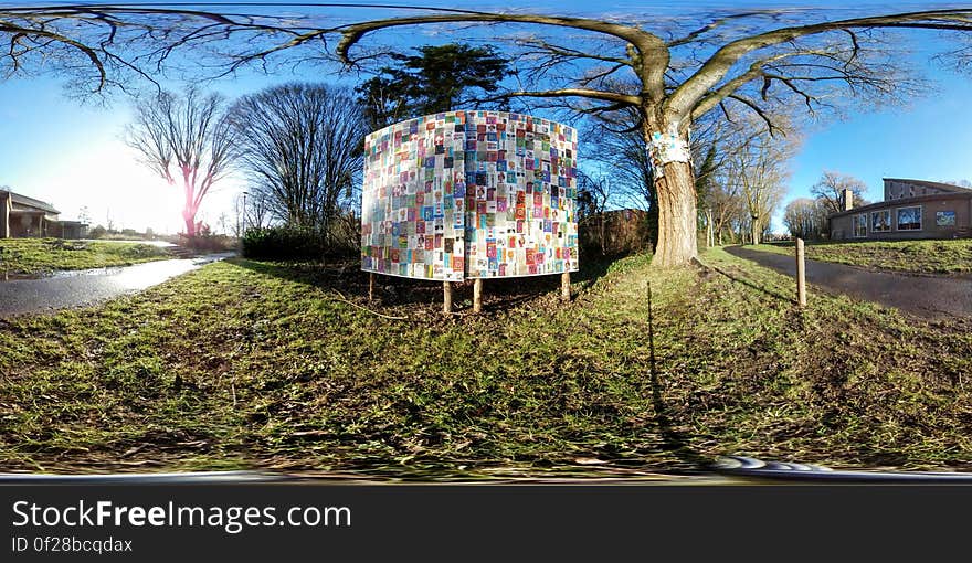 A colorful billboard beside a tree in a park, panoramic view. A colorful billboard beside a tree in a park, panoramic view.