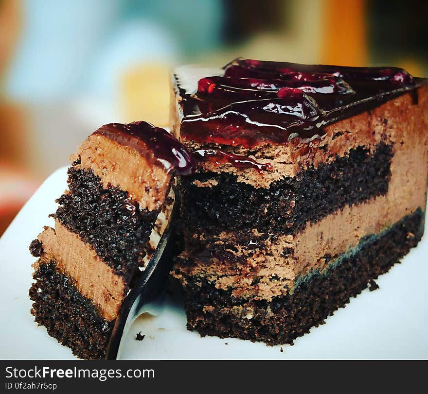 A chocolate cake with frosting and fruit jelly on top. A chocolate cake with frosting and fruit jelly on top.