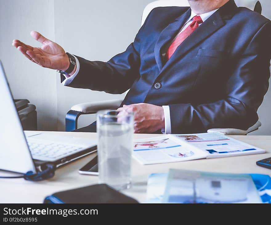 A businessman sitting at a laptop presenting his idea in a meeting. A businessman sitting at a laptop presenting his idea in a meeting.