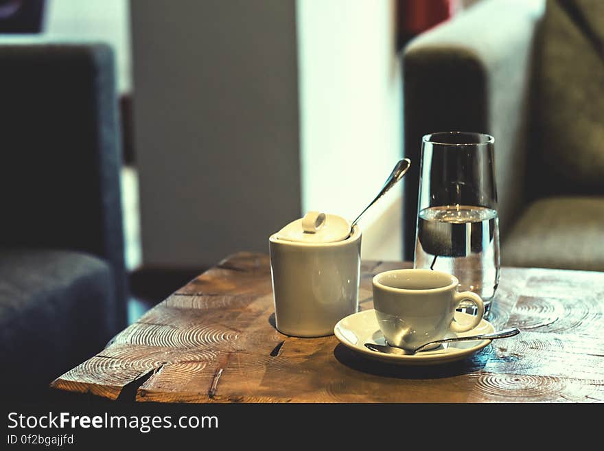 A cup of coffee and a glass of water on a coffee house table. A cup of coffee and a glass of water on a coffee house table.