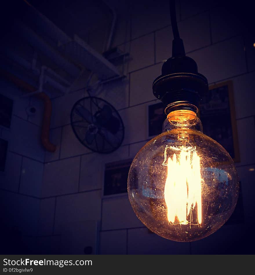 An old incandescent light bulb hanging from the ceiling.