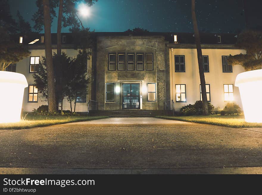 A building and courtyard lighting in the shape of giant flower pots shining brightly at night. A building and courtyard lighting in the shape of giant flower pots shining brightly at night.