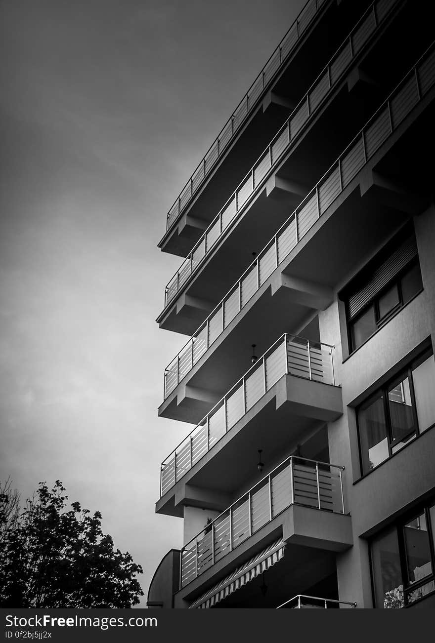 Monochrome view looking up high rise apartment building from low perspective.