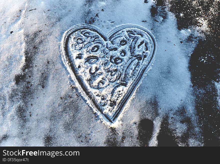 A heart drawn in snow on an icy surface. A heart drawn in snow on an icy surface.