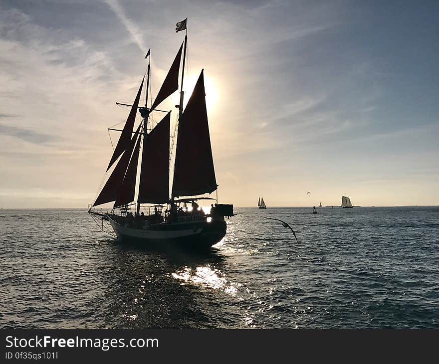 A sailboat on still sea surface at sunset. A sailboat on still sea surface at sunset.