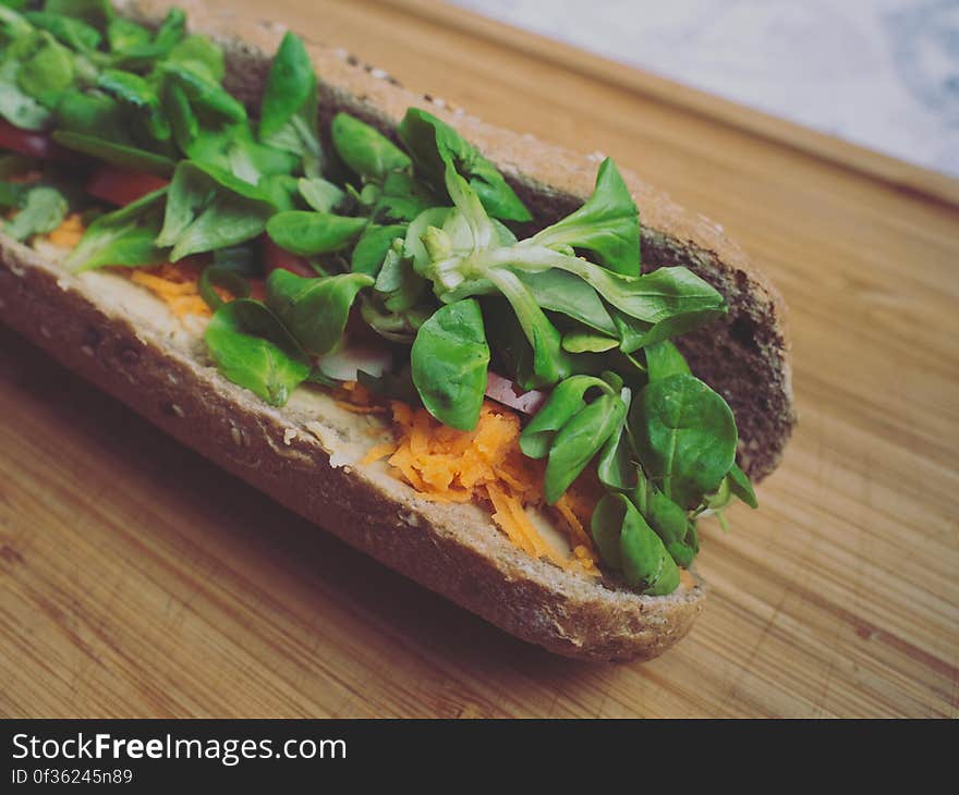 A filled whole baguette with salad and vegetables.