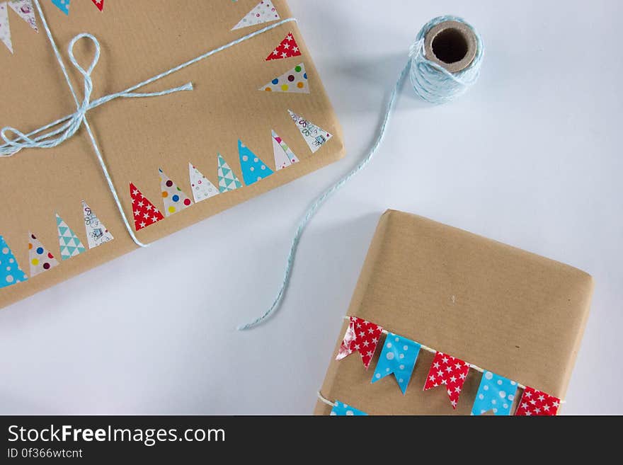 A pair of Christmas presents wrapped in brown paper tied with string.