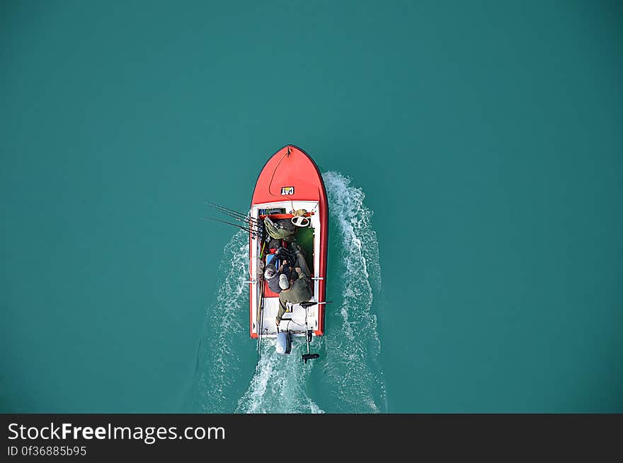 An aerial view of fishermen on a motor boat on a turquoise water surface. An aerial view of fishermen on a motor boat on a turquoise water surface.