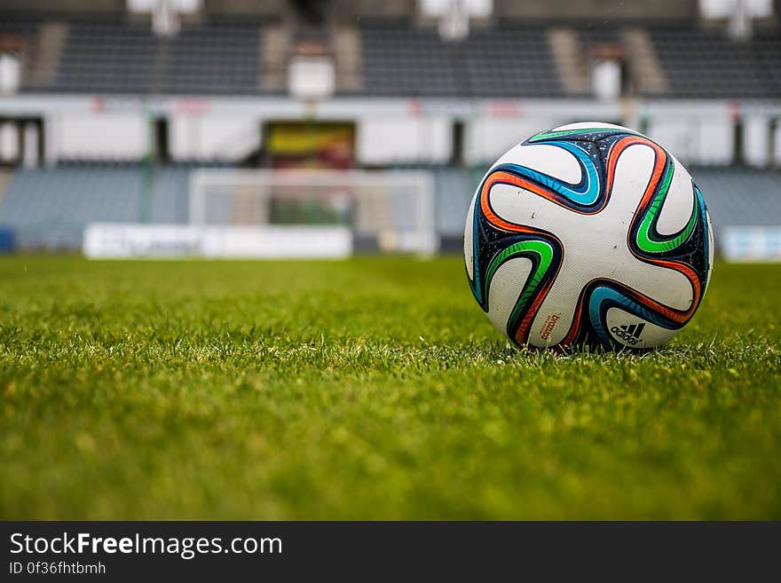 Blue Orange Black Green White Adidas Soccer Ball on Green Field