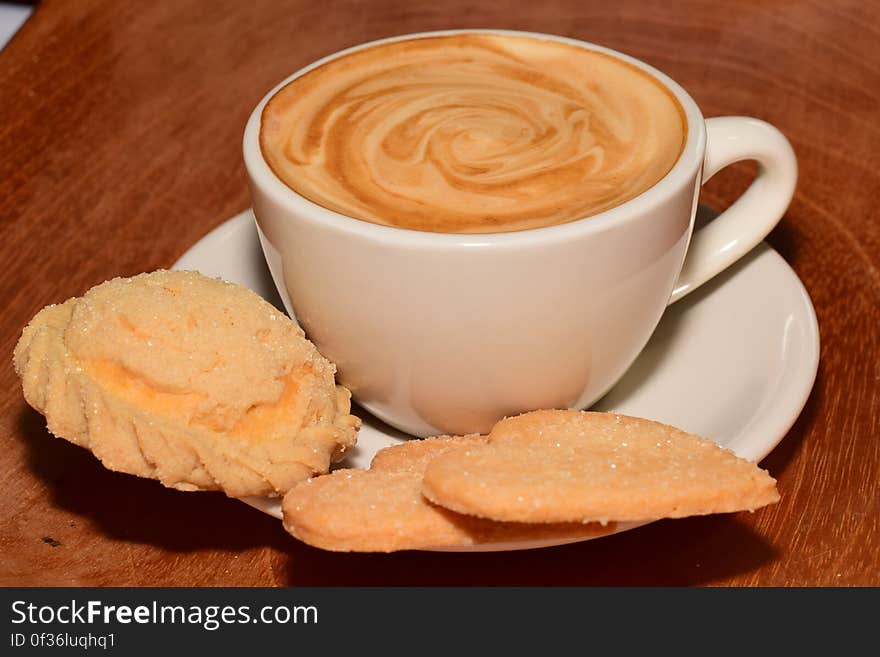 A cup of cappuccino coffee and sweet cookies. A cup of cappuccino coffee and sweet cookies.