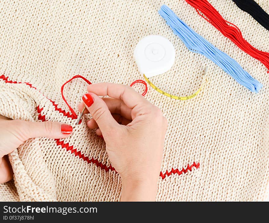 Person Embroidering a Beige Textile