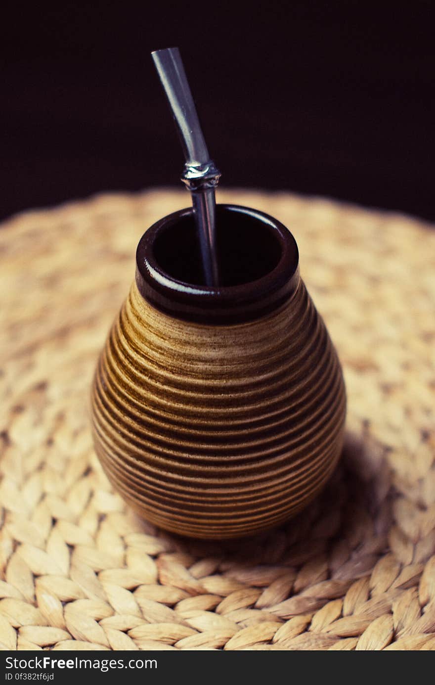 Brown and Beige Ceramic Container With Silver Inside on Brown Braided Textile