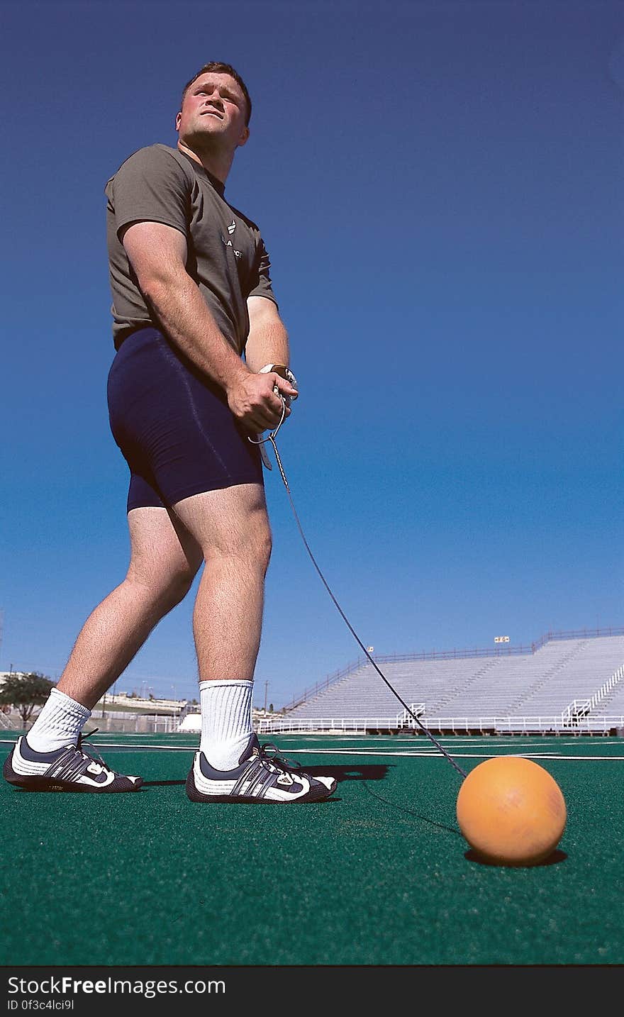 Man Wearing Grey Shirt Swinging Orange Ball