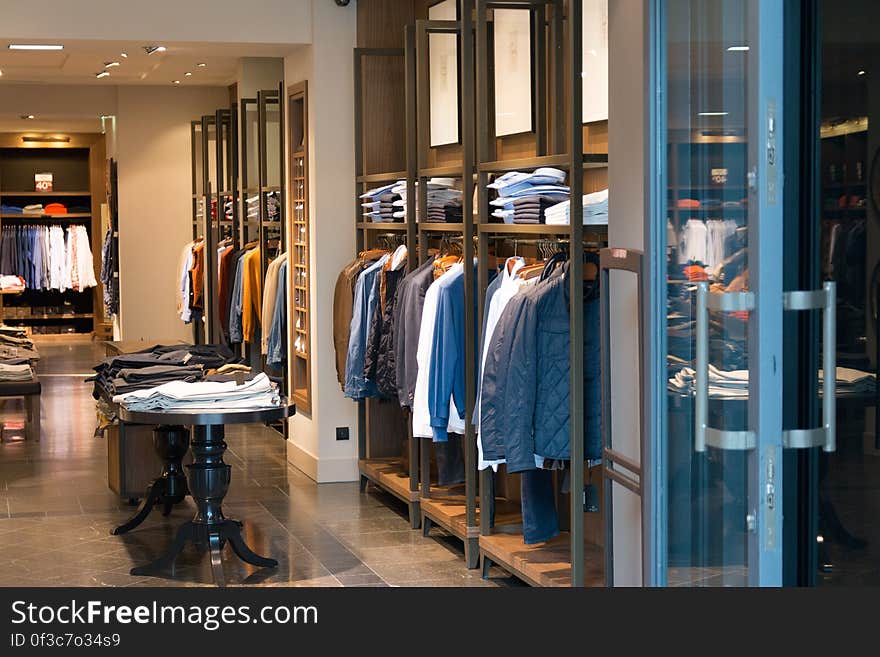 Interior of boutique clothing store with hanger and shelf displays.