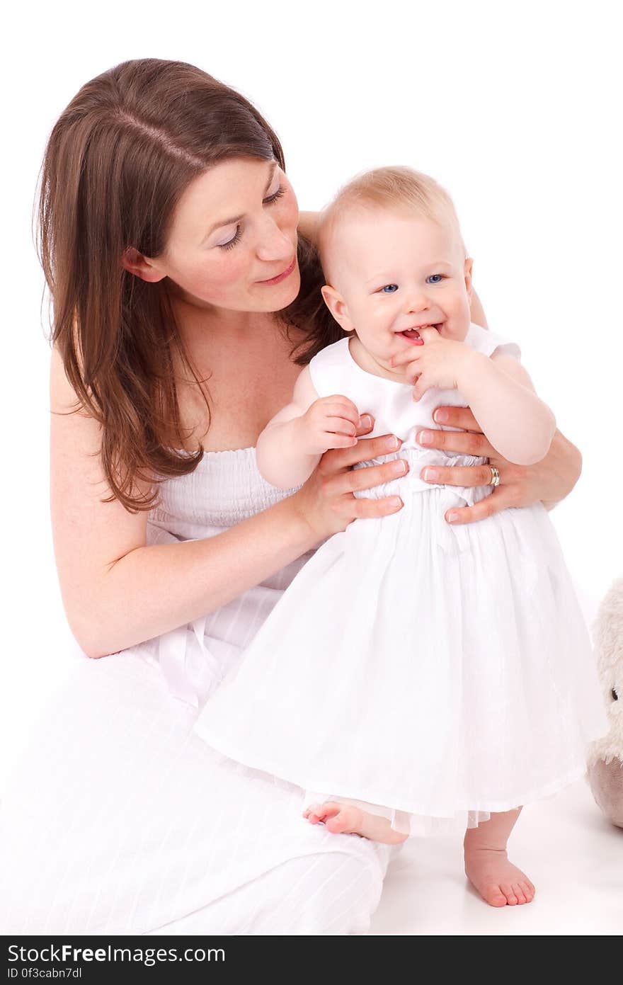 Brown Haired Woman Wearing White Strapless Dress Holding Bay Wearing White Sleeveless Dress