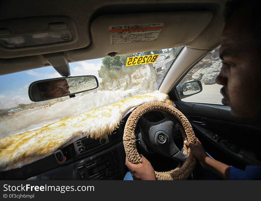 Abdirizaq Mohamed Abdi Abdulle, a driver with the Mogadishu Taxi Company drives through the streets of the Somali capital Mogadishu, 01 September 2013. Operating since the end of May of this year in the city&#x27;s dusty and once again bustling streets and thoroughfares, the MTC&#x27;s distinctive yellow and purple cars offer customers taxi fares around Mogadishu at competitive rates and in the first 3 months of operations, the company has increased it&#x27;s fleet of vehicles from an initial 25 to over 100. The company, according to Abdirizaq, also enables employment opportunities for Somalia&#x27;s youth following two decades of conflict in the Horn of Africa nation that shattered a generation. Now, thanks to the relative peace that has followed the departure of the Al-Qaeda-affiliated extremist group Al Shabaab from the city; an internationally recognised government for the first time in years and thousands of Diaspora Somalis returning home to invest in and rebuild their country, the MTC is one of many new companies establishing itself in the new Mogadishu and offering services that were hitherto impossible to provide. AU-UN IST PHOTO / STUART PRICE. Abdirizaq Mohamed Abdi Abdulle, a driver with the Mogadishu Taxi Company drives through the streets of the Somali capital Mogadishu, 01 September 2013. Operating since the end of May of this year in the city&#x27;s dusty and once again bustling streets and thoroughfares, the MTC&#x27;s distinctive yellow and purple cars offer customers taxi fares around Mogadishu at competitive rates and in the first 3 months of operations, the company has increased it&#x27;s fleet of vehicles from an initial 25 to over 100. The company, according to Abdirizaq, also enables employment opportunities for Somalia&#x27;s youth following two decades of conflict in the Horn of Africa nation that shattered a generation. Now, thanks to the relative peace that has followed the departure of the Al-Qaeda-affiliated extremist group Al Shabaab from the city; an internationally recognised government for the first time in years and thousands of Diaspora Somalis returning home to invest in and rebuild their country, the MTC is one of many new companies establishing itself in the new Mogadishu and offering services that were hitherto impossible to provide. AU-UN IST PHOTO / STUART PRICE.