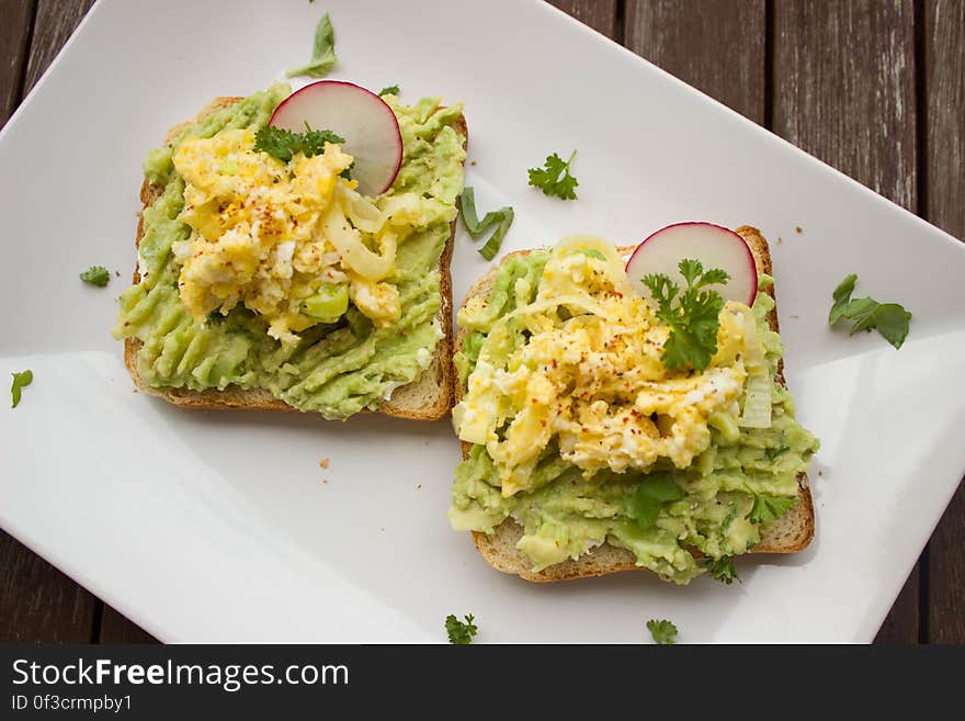 Overhead view of a cheese and salad sandwich on bread with wooden table in background. Overhead view of a cheese and salad sandwich on bread with wooden table in background.