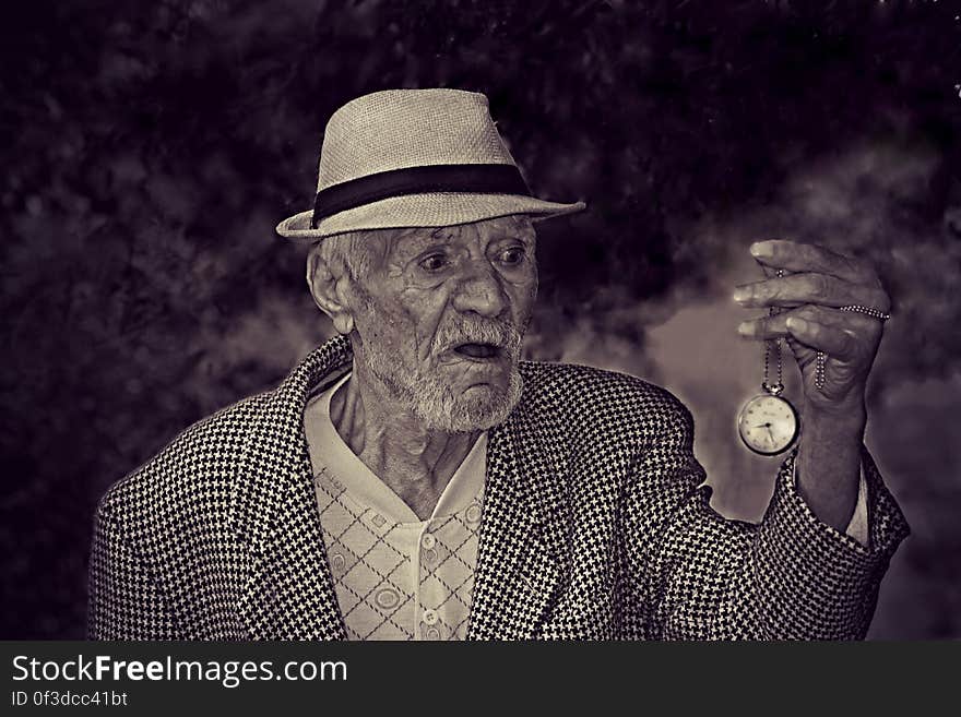 Man Holding Pocket Watch in Grayscale