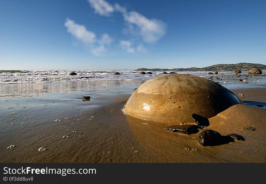 Moeraki Boulders The Moeraki Boulders are unusually large and spherical boulders lying along a stretch of Koekohe Beach on the wave cut Otago coast of New Zealand between Moeraki and Hampden. Moeraki Boulders The Moeraki Boulders are unusually large and spherical boulders lying along a stretch of Koekohe Beach on the wave cut Otago coast of New Zealand between Moeraki and Hampden