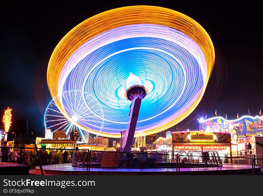 A long exposure of a spinning carousel in an amusement park. A long exposure of a spinning carousel in an amusement park.