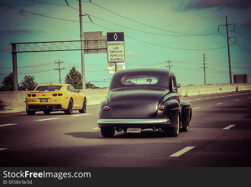 Classic car driving on highway with vintage blue filter effect. Classic car driving on highway with vintage blue filter effect.