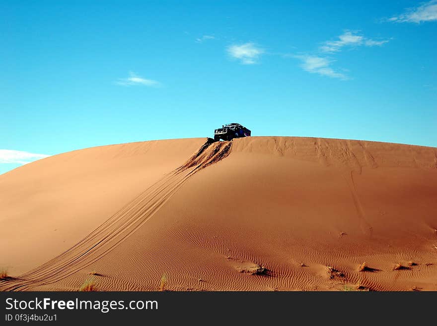 Car on Top of Sand Cliff during Day Time