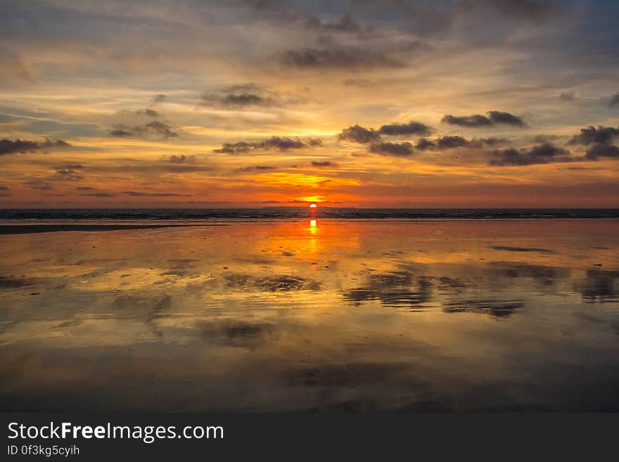 Sunset and clouds reflecting in still waters on horizon. Sunset and clouds reflecting in still waters on horizon.