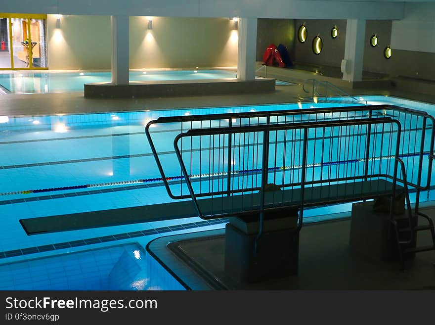 An empty swimming pool and spring board.