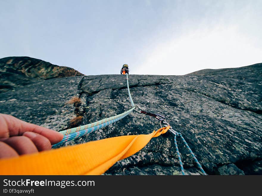 A rock climber hanging from a rope. A rock climber hanging from a rope.