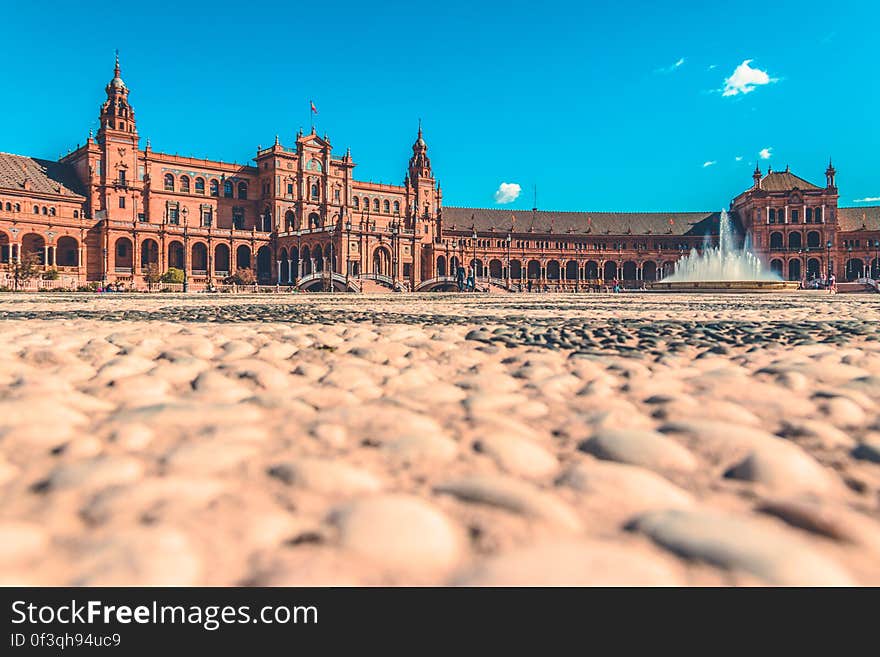 A colossal historic palace with arched porch and a fountain in front. A colossal historic palace with arched porch and a fountain in front.