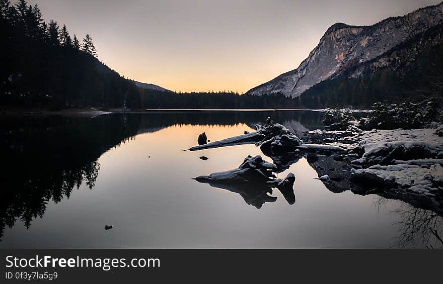 A calm mountain lake at sunset.