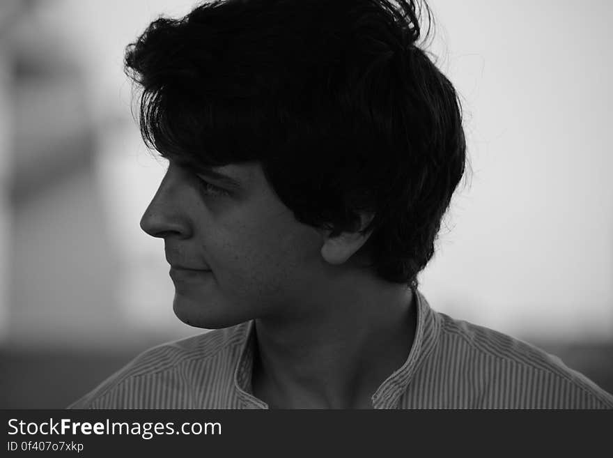 Black and white side portrait of sad handsome young man,