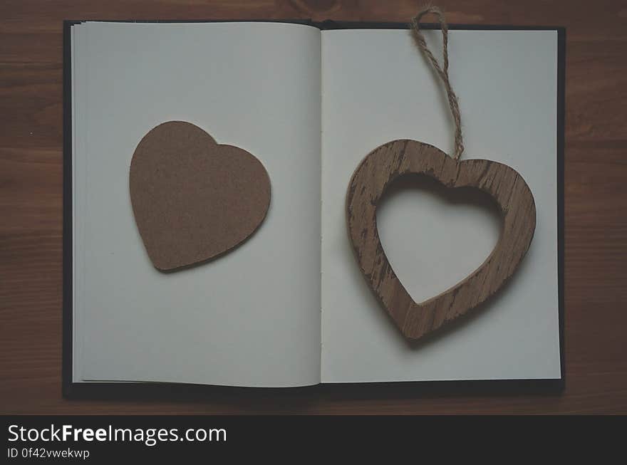 Brown Wooden Heart Shape Pendant on White Book