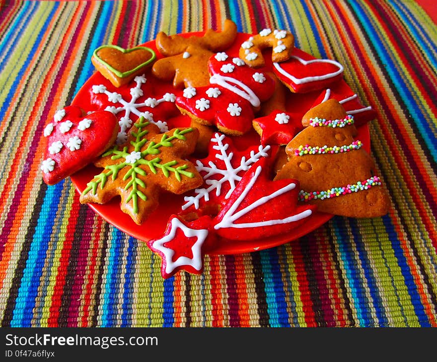 Decorated Christmas handmade cookies on a colorful tablecloth. Decorated Christmas handmade cookies on a colorful tablecloth.