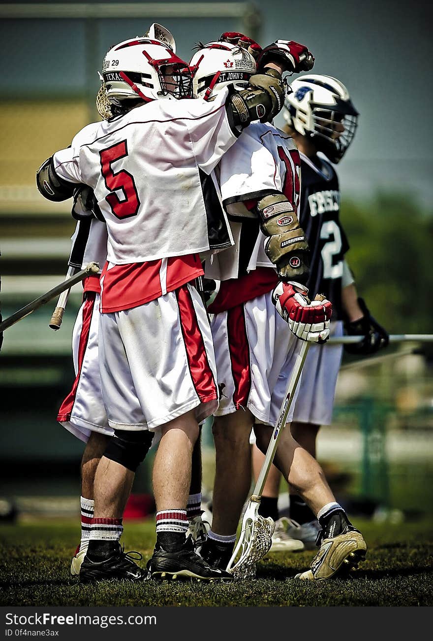 Group of male lacrosse players hugging as they celebrated a goal or win. Group of male lacrosse players hugging as they celebrated a goal or win.