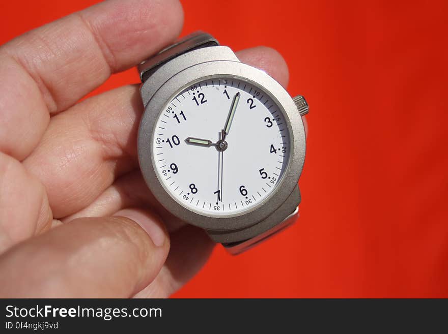 Person Holding Grey Round Analog Watch at 10:07