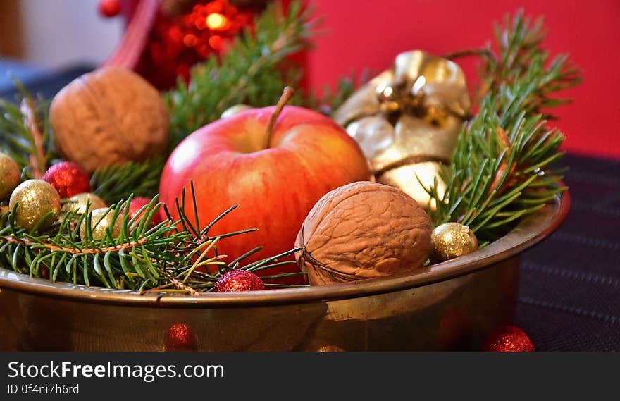 Christmas centerpiece in bowl with pine boughs, apple, walnuts and colorful ornaments. Christmas centerpiece in bowl with pine boughs, apple, walnuts and colorful ornaments.